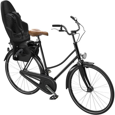 Thule Yepp 2 Maxi Rack Mount in Midnight Black attached to a black bicycle, featuring a child seat and brown saddle.