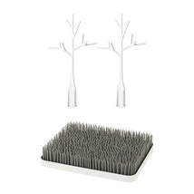 Boon LAWN drying rack featuring a gray grass-like base with two white twig accessories for effective drying.