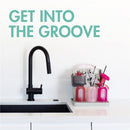 Customizable vertical drying rack with colorful containers for drying bottles and utensils next to a sleek black faucet.