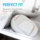 Inflatable Boon PUFF+ baby bather positioned in a sink, with tags indicating safety and use instructions.