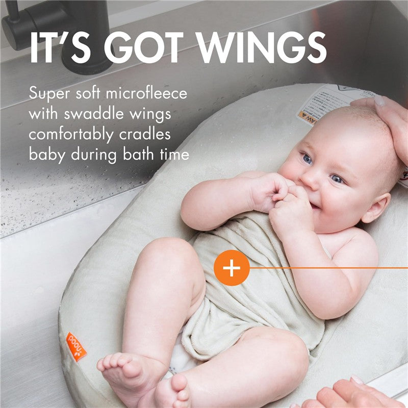 Boon PUFF+ Inflatable Baby Bather cradling a smiling baby wrapped in soft microfleece during bath time.