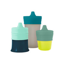 Universal silicone sippy lids in green, three-pack, fits various cups; features soft, colorful spouts for easy drinking.