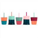 Three silicone straw lids in green and various colors for children’s cups, designed for spill-proof drinking.