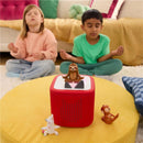 Children meditating with closed eyes, seated on a rug, next to the Tonies audio toy featuring a sloth figurine.