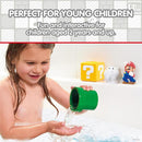 Young child playing with Toomies My Mario Pour & Nest Bath Toy, pouring water from a green cup into their hand.
