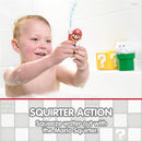 Child holding a Mario bath toy that squirts water, with Mario figurine in hand and colorful question mark blocks in the background.