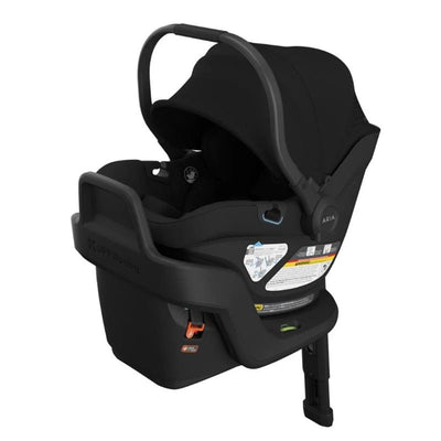 Lightweight Uppababy Aria V2 infant car seat in black, featuring a sunshade, adjustable handle, and safety labels.
