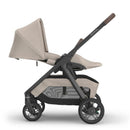 Uppababy Kona stroller in Sandstone Mélange, featuring a canopy, adjustable seat, and storage basket.