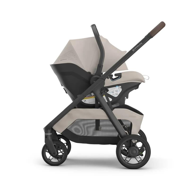 Uppababy Kona stroller with Aria V2 infant car seat in Ada Sandstone Mélange, featuring a sleek design and protective canopy.