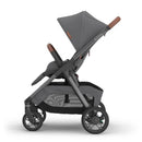 Uppababy Kona stroller in graphite color with a brown handlebar, featuring a reclining seat and spacious storage basket.