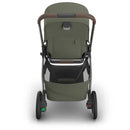 Uppababy Kona Stroller in Meadow Green with brown handle, showcasing the bassinet attachment and storage basket below.