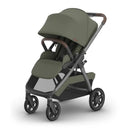 Uppababy Kona Stroller in Meadow Green with a spacious seat, adjustable canopy, and brown handlebar.
