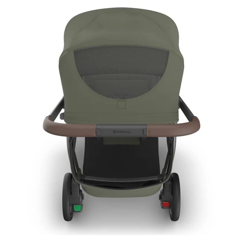 Uppababy Kona Stroller with Bassinet V3 Bundle in Meadow Green, featuring a brown handle and a mesh panel on the bassinet.
