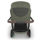 Uppababy Kona Stroller with Bassinet V3 Bundle in Meadow Green, featuring a brown handle and a mesh panel on the bassinet.