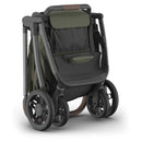 Uppababy Kona Stroller and Bassinet V3 Bundle in Meadow Green, featuring a sleek design with a foldable frame and large wheels.