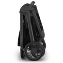 Uppababy Kona Stroller & Bassinet V3 Bundle in black, shown in a folded position, highlighting its compact design and wheels.