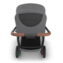 Uppababy Kona Stroller with Rowan bassinet, featuring a grey canopy and brown handlebar, viewed from behind.