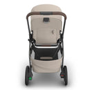 Uppababy Kona stroller in Ada (Sandstone Mélange) color, featuring a brown handle, spacious seat, and storage basket.