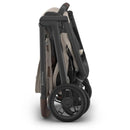 Uppababy Kona Stroller & Mesa V3 Travel System in Ada color, compactly folded with prominent wheels and handle.