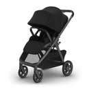 Uppababy Kona Stroller in black, featuring a large canopy, comfortable seating, and a storage basket.
