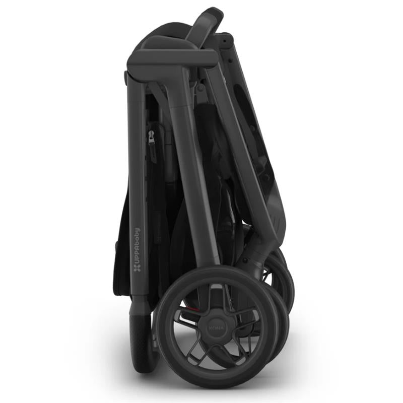 Uppababy Kona Stroller in a folded position, featuring a sleek black design and prominent wheels.