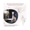 Sophie La Girafe teether stands next to a globe, showcasing its iconic design and global reach.