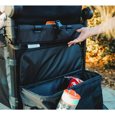 Rear view of a Wonderfold W4lux stroller showing a hand reaching into a spacious black fabric rear basket, containing snacks and a water bottle.