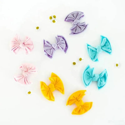 Assorted colorful Baby Bling Bows fabric hair clips on a white background.