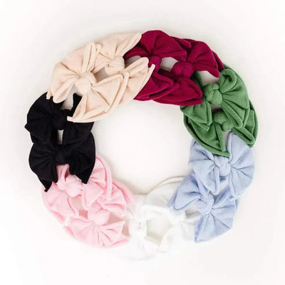 Assorted colorful Baby Bling Bows fabric hair clips for babies arranged in a circle.