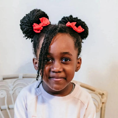 Young girl wearing Baby Bling Bows red cherry hair clips in double buns.